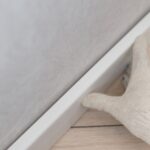 Man putting new skirting board on wall in house